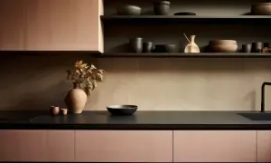 Nowoczesna kuchnia z różowymi frontami szafek i czarnym blatem. Inspiracja, jak dobrać kolor blatu kuchennego do mebli, by stworzyć harmonijną przestrzeń.