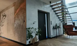 Nowoczesne wnętrze z betonem architektonicznym i grafiką na ścianie. Czy tynk dekoracyjny można malować? Tak, a efekt może być zachwycający!