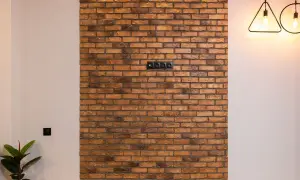 Fragment ściany z cegły dekoracyjnej z gniazdkami elektrycznymi.