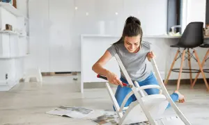 Kobieta maluje krzesło, szukając sposobu, jak pozbyć się zapachu nowych mebli.