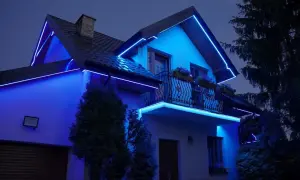 Elegancki dom oświetlony niebieską taśmą LED. Pokazuje, jak zamontować taśmę led, tworząc nowoczesną iluminację.