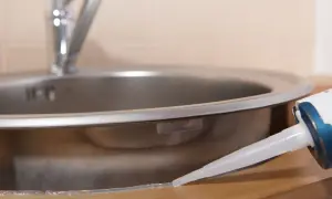 Aplikacja silikonu uniwersalnego bezbarwnego wokół zlewu kuchennego.