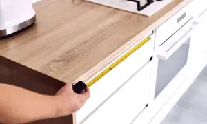 Mierzysz, ile blat wystaje przed szafki. Taśma miernicza pokazuje ok. 17 cm.