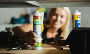 Kobieta trzyma tubę akrylu lekkiego szpachlowego Soudal. Czas schnięcia silikonu akrylowego zależy od warunków.