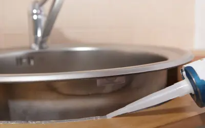 Aplikacja silikonu uniwersalnego bezbarwnego wokół zlewu kuchennego.