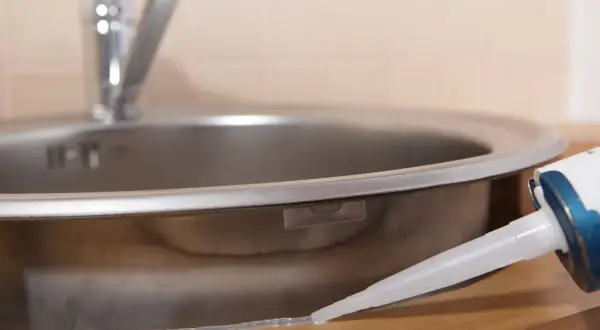 Aplikacja silikonu uniwersalnego bezbarwnego wokół zlewu kuchennego.