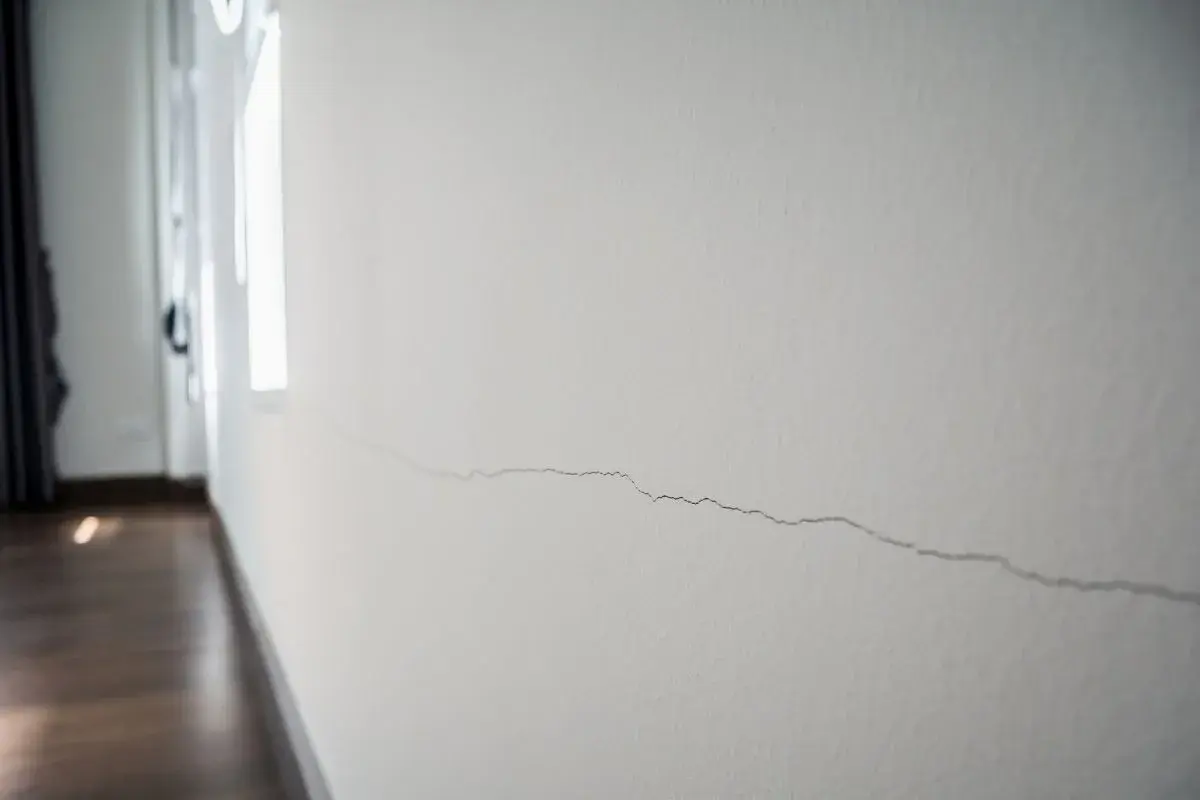 Pęknięcie na białej ścianie, które można naprawić masą akrylową do ścian.