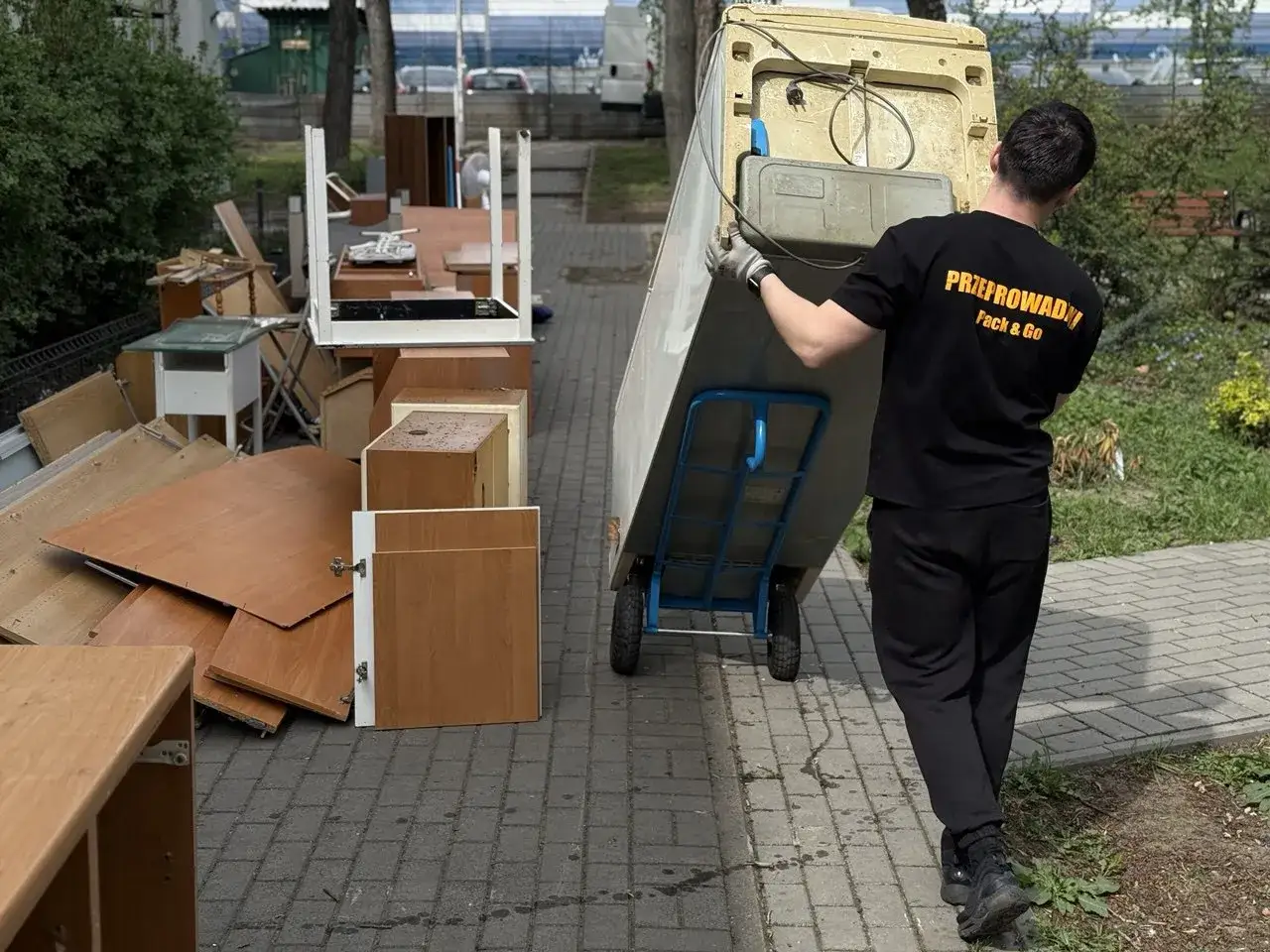 Pracownik firmy przeprowadzkowej transportuje stare meble. Szukasz miejsca, gdzie oddać stare meble Warszawa?