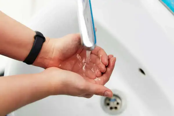 Dłonie pod bieżącą wodą z kranu. Zastanawiasz się, jak zmierzyć ciśnienie wody w kranie?