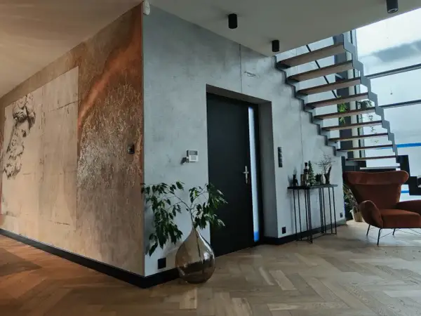 Nowoczesne wnętrze z betonem architektonicznym i grafiką na ścianie. Czy tynk dekoracyjny można malować? Tak, a efekt może być zachwycający!